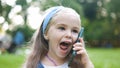 Pretty little child girl having conversation on her mobile phone in summer park Royalty Free Stock Photo