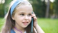 Pretty little child girl having conversation on her mobile phone in summer park Royalty Free Stock Photo