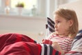 Pretty little child girl laying in bed and drink tea