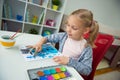 Pretty little child girl painting with colorful paint at home Royalty Free Stock Photo