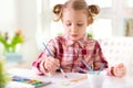 Pretty little child girl painting with colorful paint at home Royalty Free Stock Photo