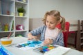 Pretty little child girl painting with colorful paint at home Royalty Free Stock Photo