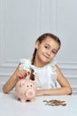 Little child girl with piggy bank at home Royalty Free Stock Photo