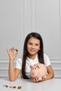 Little child girl with piggy bank at home Royalty Free Stock Photo