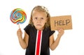 Pretty little child holding lollipop and help sign in children sugar excess