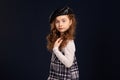 Stylish brunette kid is posing in studio on a black background. Children`s fashion. Royalty Free Stock Photo