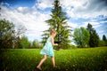 A pretty little funny girl with a laptop on the grass in nature Royalty Free Stock Photo