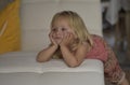 TV.Little girl watching TV lying on the couch.