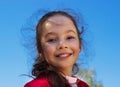 Pretty little girl against blue summer sky background Royalty Free Stock Photo