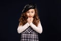 Stylish brunette kid is posing in studio on a black background. Children`s fashion. Royalty Free Stock Photo