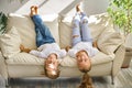 Pretty little girl and boy are lying on sofa in living room Royalty Free Stock Photo