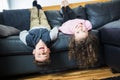 Pretty little girl and boy are lying on their backs on sofa Royalty Free Stock Photo