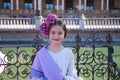 a pretty little girl dancing flamenco dressed in a beige dress with ruffles and purple fringes sitting in a famous square in Royalty Free Stock Photo