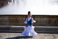 A pretty little girl dancing flamenco dressed in a white dress with ruffles and blue fringes in a famous square in seville, spain Royalty Free Stock Photo