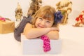 pretty little girl in a dress waiting at the foot of the Christmas tree for the opening of presents Royalty Free Stock Photo