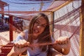 Pretty little girl dressed in a white and blue striped dress locked in a net covered cage. Isolation concept Royalty Free Stock Photo