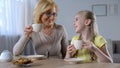 Pretty little girl drinking tea with her nanny and happily smiling, traditions Royalty Free Stock Photo