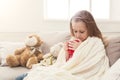 Beautiful little girl drinking tea at home