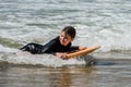 pretty little girl enjoying surfing the waves with a bodyboard during her vacation Royalty Free Stock Photo