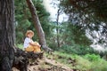 Pretty little girl in green forest enjoys the silence and beauty of nature. Child dreaming and thinking with the view on nature Royalty Free Stock Photo