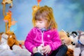 Portrait of a pretty little girl in her room with her stuffed animals Royalty Free Stock Photo