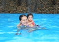 Pretty little girl with her mother playing in swimming pool outdoors Royalty Free Stock Photo