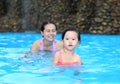 Pretty little girl with her mother playing in swimming pool outdoors Royalty Free Stock Photo