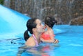 Pretty little girl with her mother playing in swimming pool outdoors Royalty Free Stock Photo