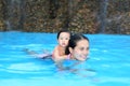 Pretty little girl with her mother playing in swimming pool outdoors Royalty Free Stock Photo