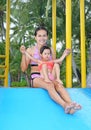 Pretty little girl with her mother sliding in swimming pool outdoors Royalty Free Stock Photo