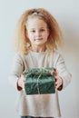 Pretty little girl holding gift box, Christmas time. Focus on bo Royalty Free Stock Photo