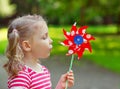 Pretty little girl holds windmill in hand Royalty Free Stock Photo