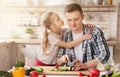 Pretty little girl is kissing her father cheek at kitchen Royalty Free Stock Photo