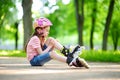 Pretty little girl learning to roller skate on beautiful summer day in a park Royalty Free Stock Photo