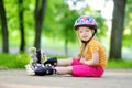 Pretty little girl learning to roller skate on beautiful summer day in a park Royalty Free Stock Photo