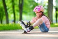 Pretty little girl learning to roller skate on beautiful summer day in a park Royalty Free Stock Photo