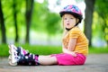 Pretty little girl learning to roller skate on beautiful summer day in a park Royalty Free Stock Photo