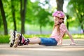 Pretty little girl learning to roller skate on beautiful summer day in a park Royalty Free Stock Photo