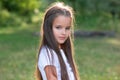 Pretty little girl with long brown hair posing summer nature outdoor. Kid`s portrait. Royalty Free Stock Photo