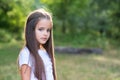 Pretty little girl with long brown hair posing summer nature outdoor. Kid`s portrait. Royalty Free Stock Photo