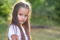 Pretty little girl with long brown hair posing summer nature outdoor. Kid`s portrait Royalty Free Stock Photo