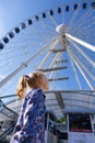 Pretty little girl looks at ferris wheel against a blue sky Royalty Free Stock Photo