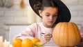 Pretty little girl making jack pumpkin and preparing for Halloween eve party