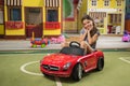 Pretty little girl with mini car at game center.