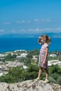 Girl looks to far away squinting in sunshine on city beach background Royalty Free Stock Photo