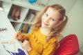 Pretty little girl paiting with colorful  crayon and paintbrush Royalty Free Stock Photo