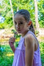 Pretty little girl picking a flower on a path surrounded by nature