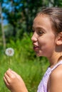 Pretty little girl picking a flower on a path surrounded by nature