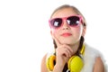 A pretty little girl with pink glasses and yellow headphones