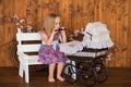 Pretty little girl play with retro pram, baby stroller